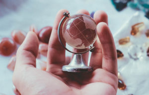 Cupped hands holding a small globe