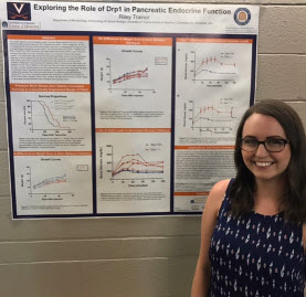Riley, undergraduate student in front of her poster